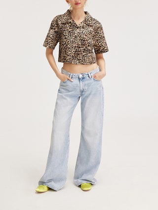 Image may contain Clothing Pants Jeans Blouse and Person