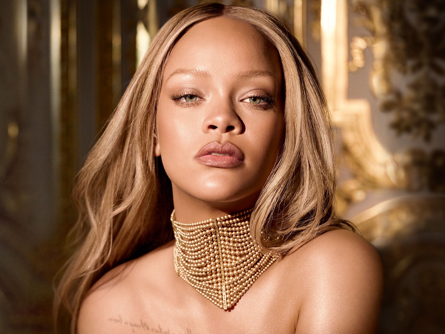 Rihanna embodies the iconic J'adore Dior perfume bottle in a golden corset dress